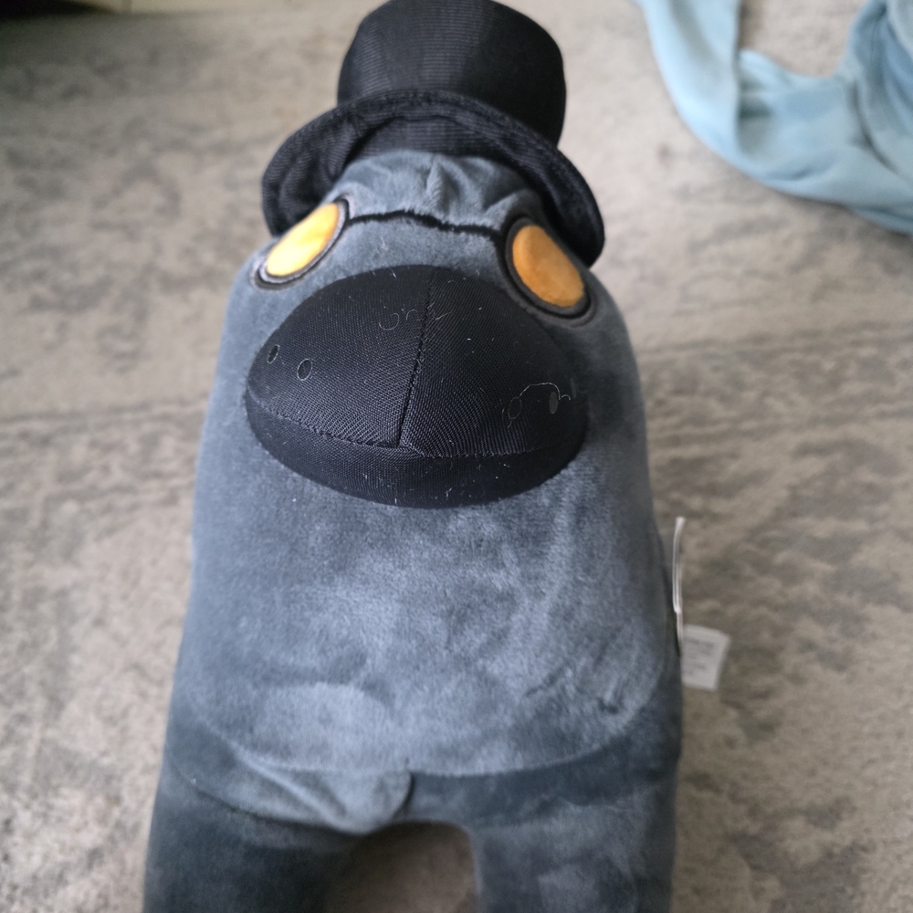Gray Plush Toy with Black Hat and Yellow Eyes